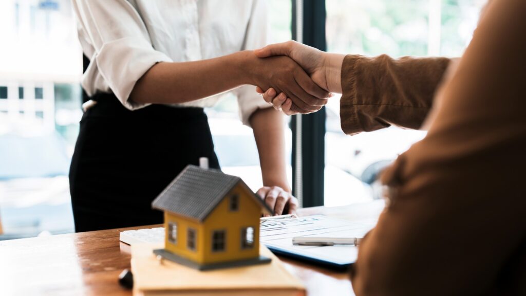 Agente immobiliare e cliente si stringono la mano dopo una mediazione ben riuscita